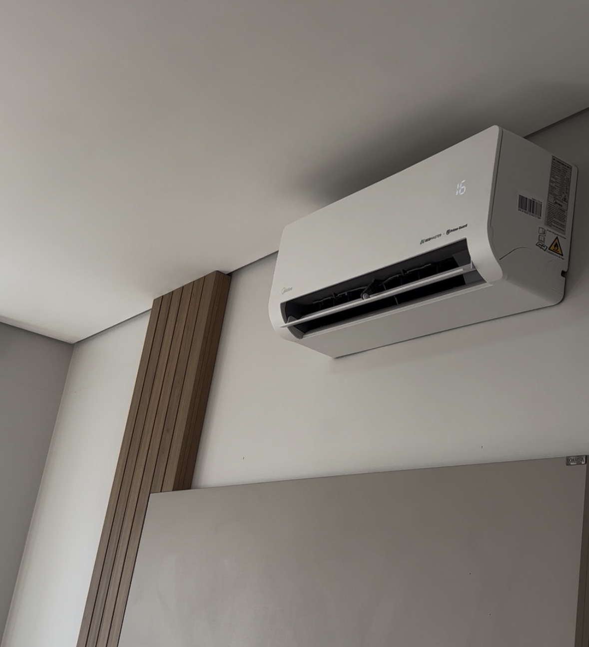 Split Midea instalado em sala com detalhe ripado de madeira